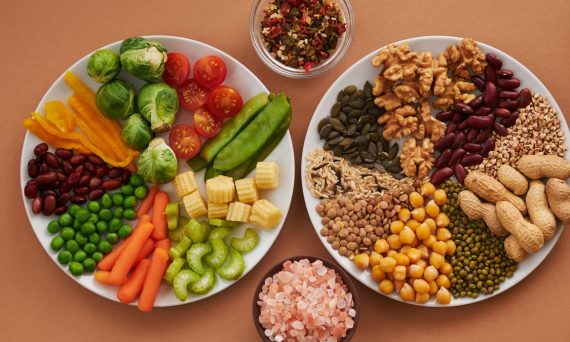 Vibrant display of assorted vegetables, legumes, nuts, and seeds on plates, perfect for healthy eating images.